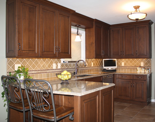 Maple Cabinets with Matte Brown and Black Glaze, Cambria Berkeley Overhang Breakfast Bar, Porcelain Flooring and Ceramic Backsplash Tiles